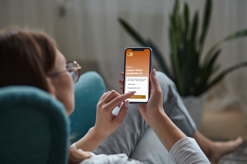 Kobieta w fotelu prowadząca rozmowę z Agentem AI Profitroom przez telefon komórkowy
