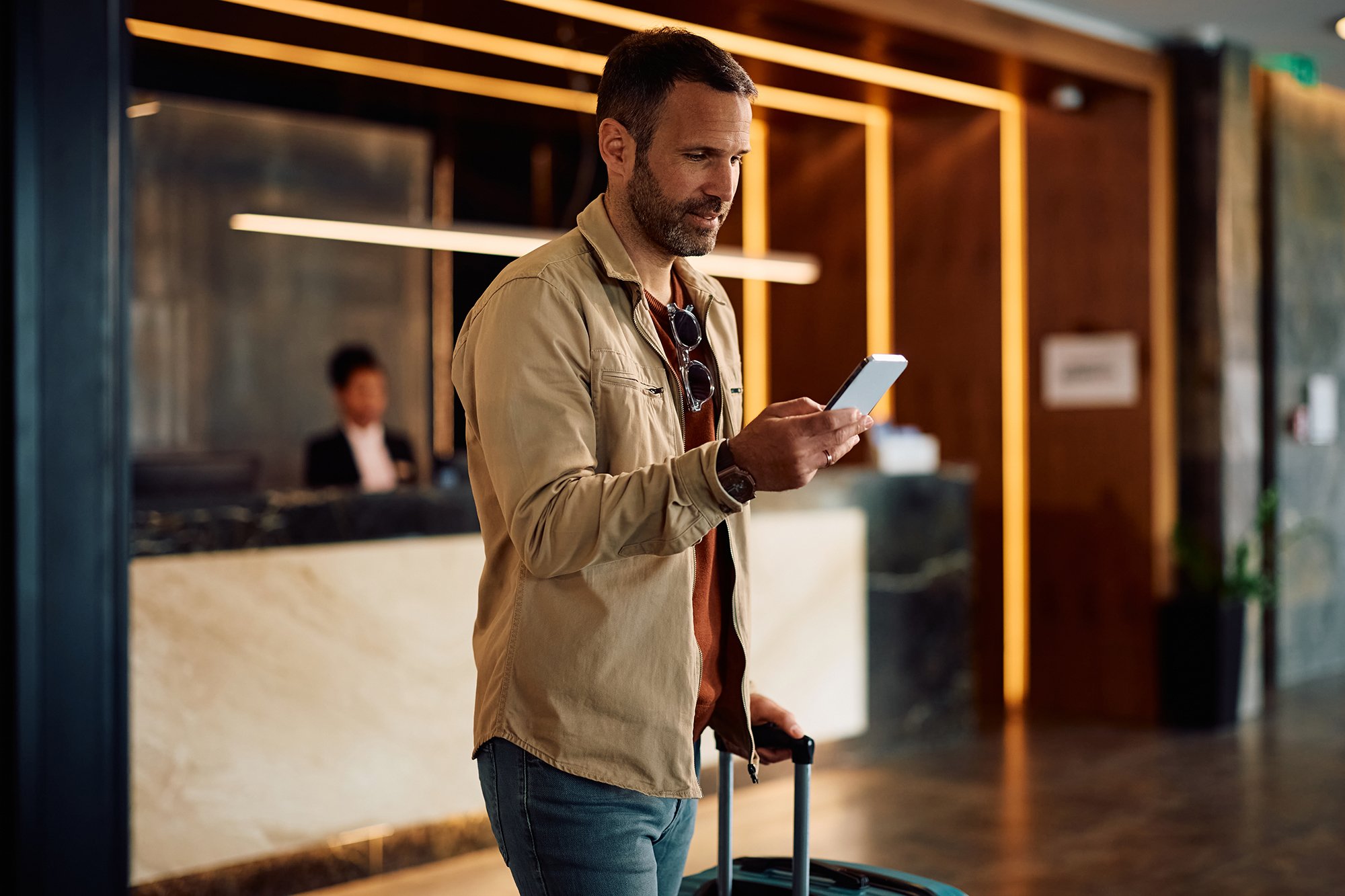 man-with-travel-bag-texting-on-mobile-phone-while-2025-03-24-23-14-31-utc